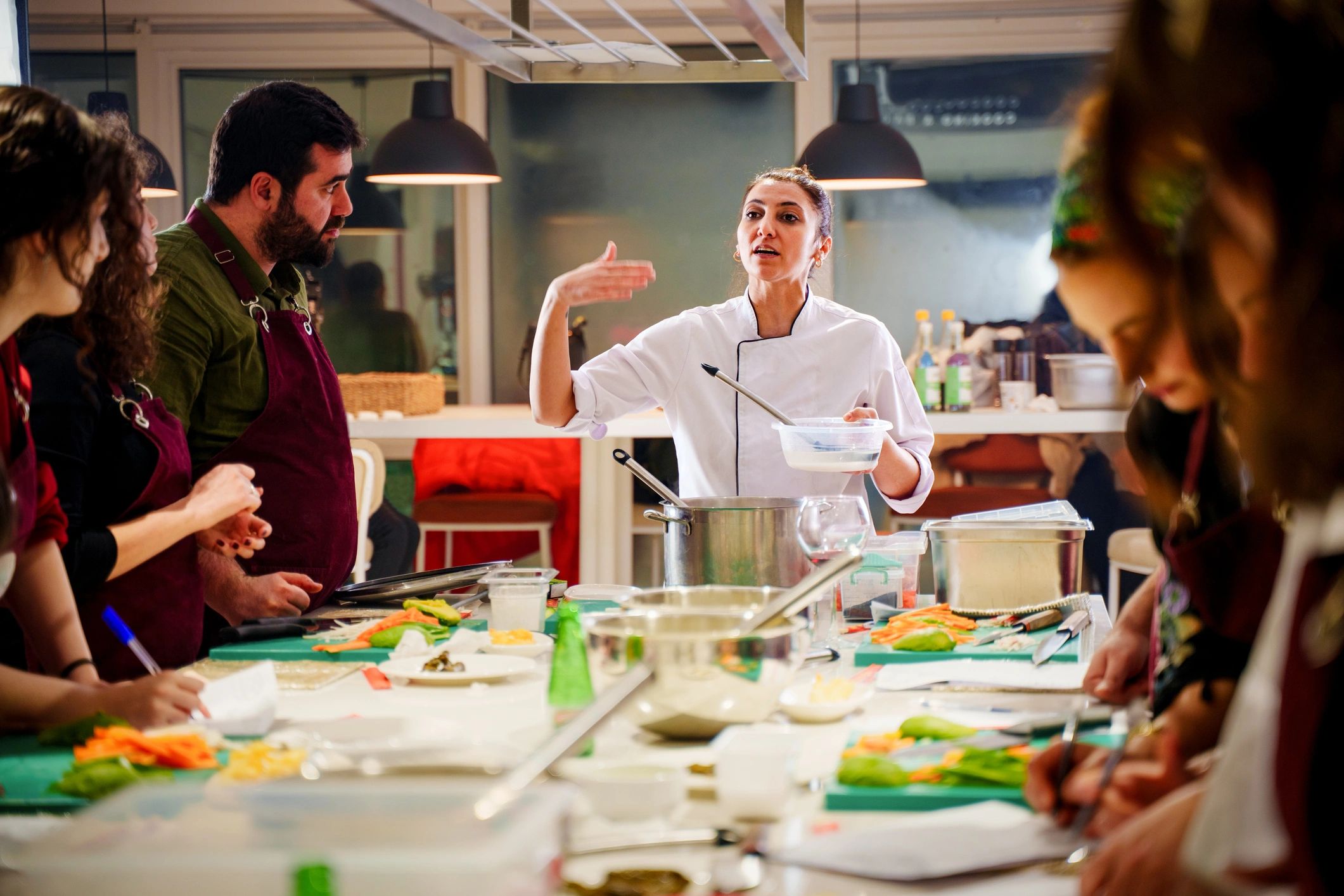 Professional chef leading a hands-on cooking class in a modern kitchen